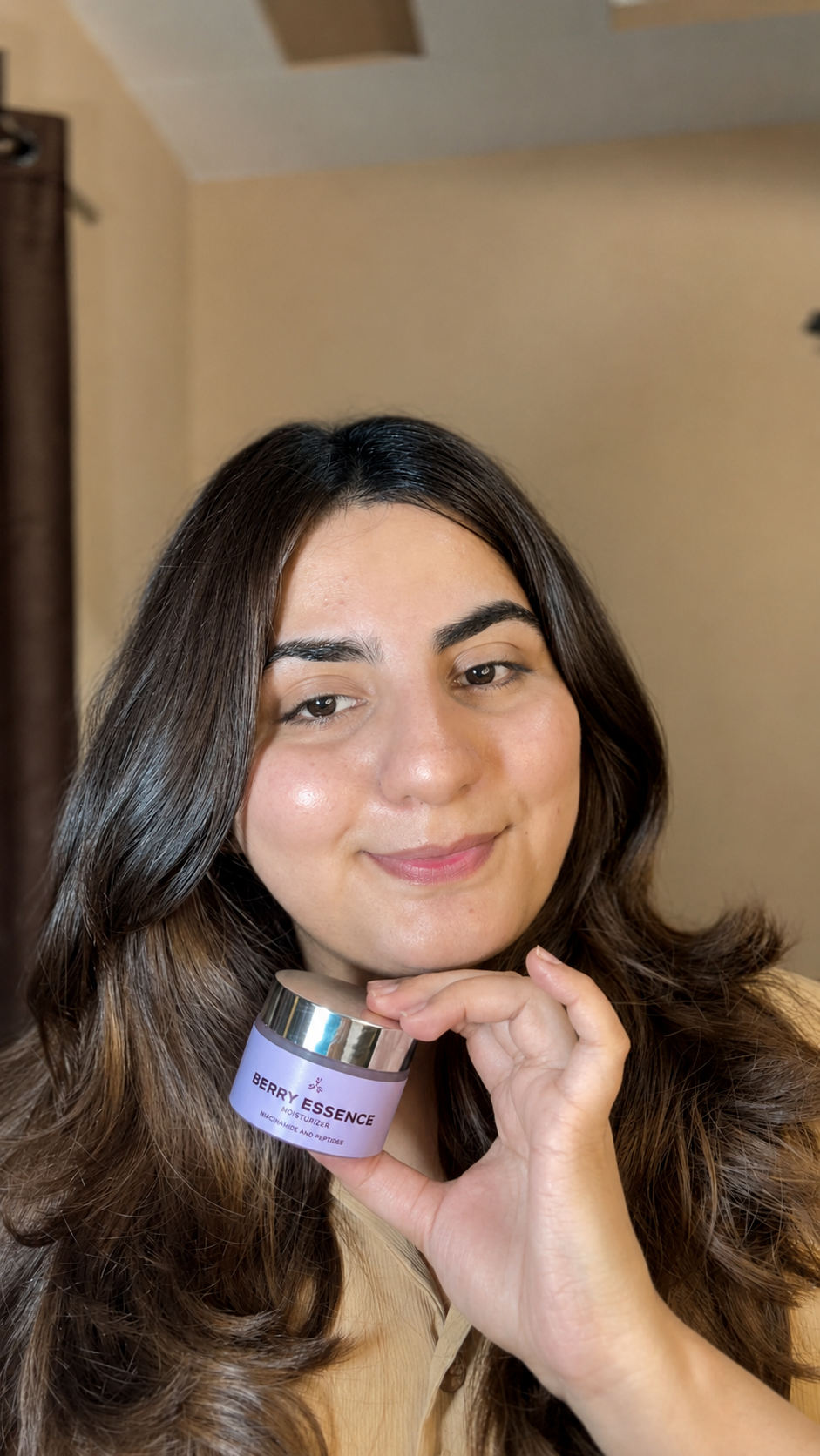 Woman holding a purple jar with text, against a neutral background